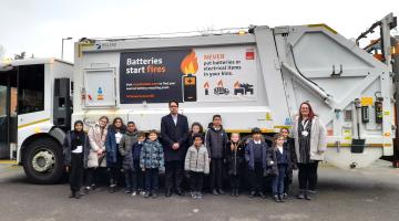 Councillor Haroon with Henry Green Primary School pupils standing in front of a bin truck