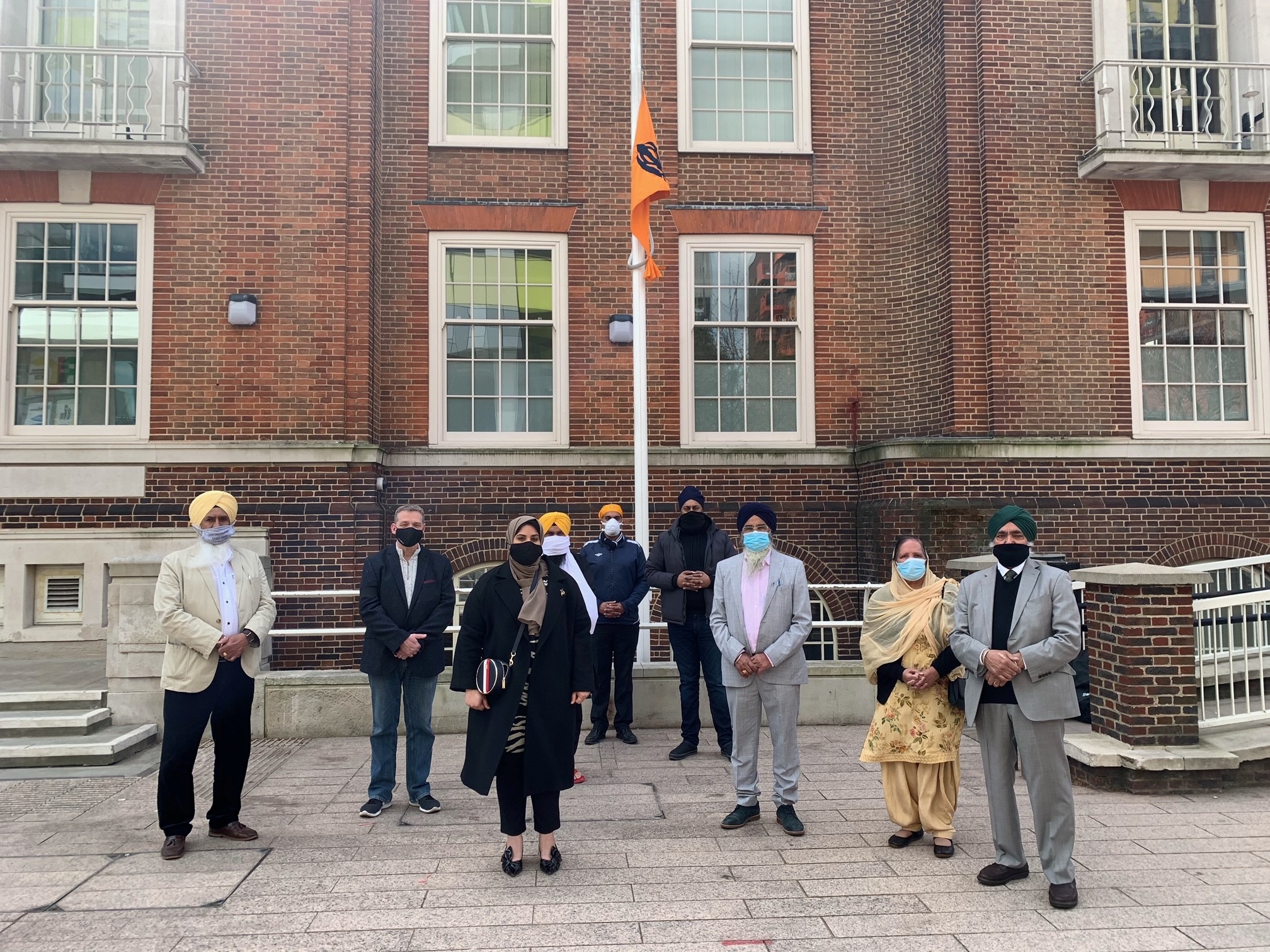 group outside town hall with the khalsa flag