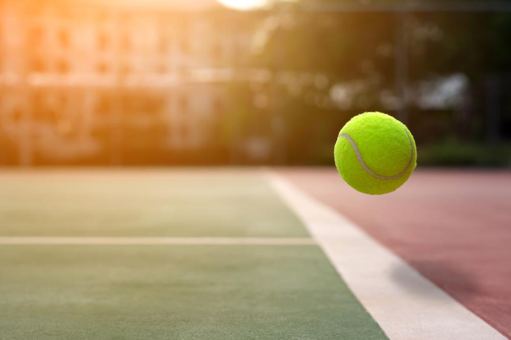 Image of a tennis ball about to cross the line to be out. 