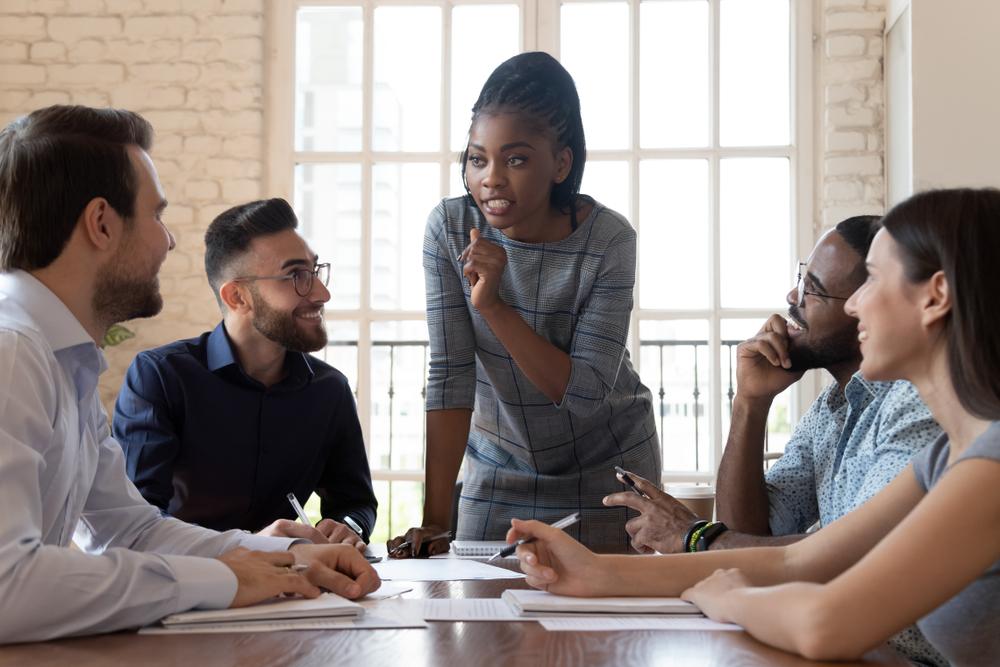 Image of a business meeting with 5 adults. 