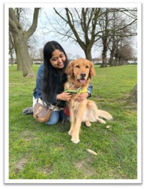Photo of Ruqaiya and her guide dog sitting in the park
