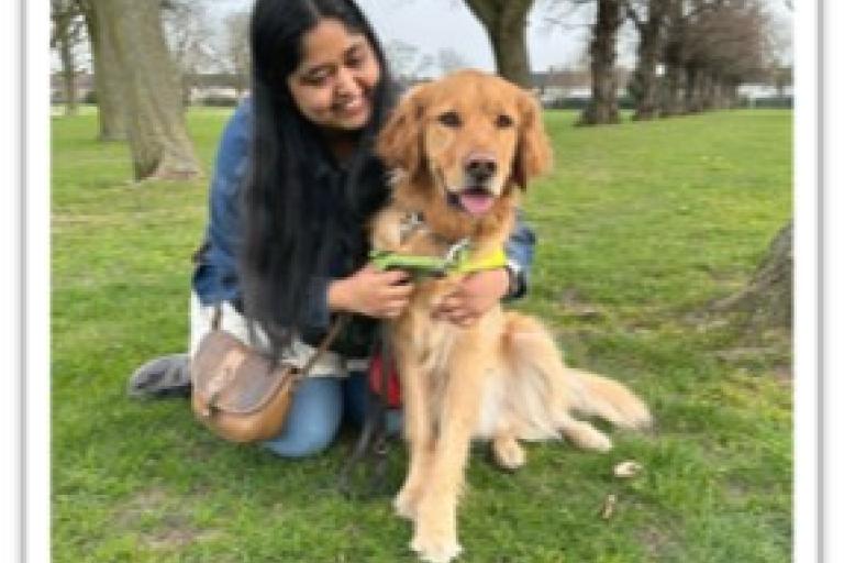 Photo of Ruqaiya and her guide dog sitting in the park