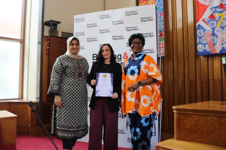 Danielle Everitt is showing their winning certificate in the Town Hall