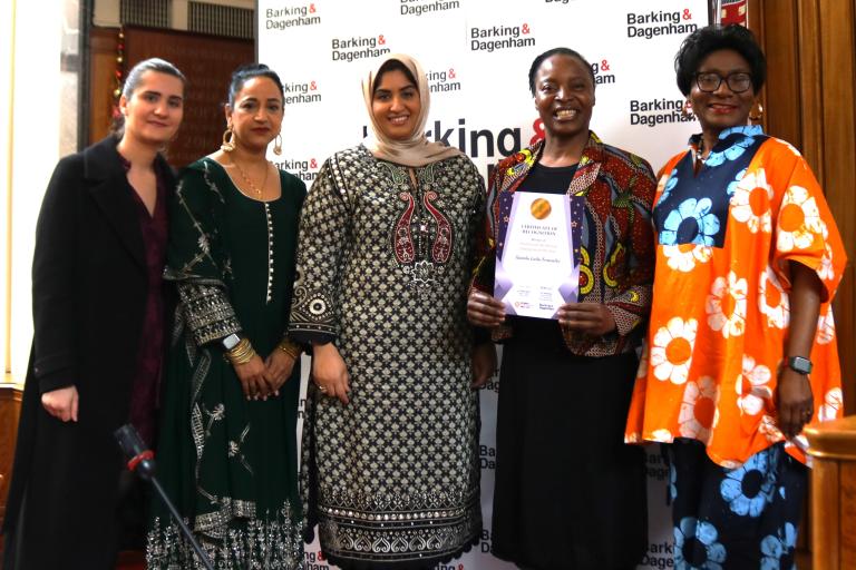 Nassaba Guiba Fernandes is showing their winning certificate in the Town Hall