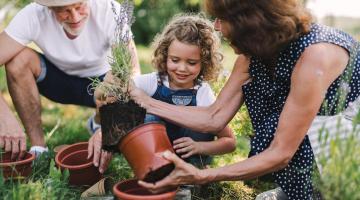 man and woman gardening with young child