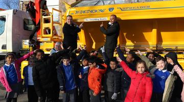 Image of school children and councillors in front of the newly named gritter