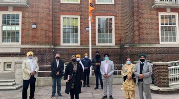 group outside town hall with the khalsa flag