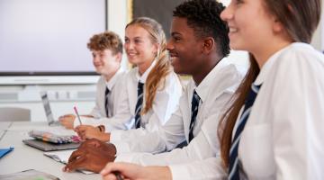 Secondary school children in class smiling