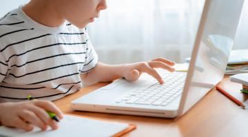 child learning on laptop at home