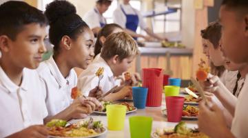 children eating a school meal in canteen