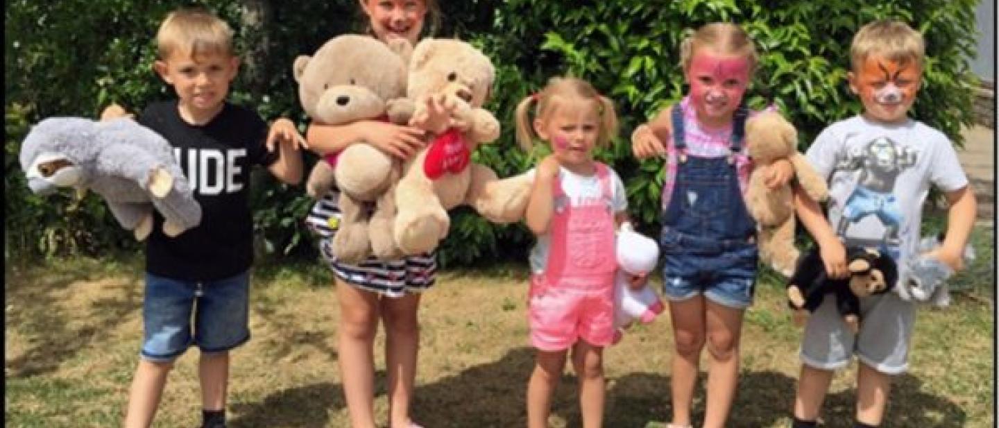 photo of children holding teddy bears. 