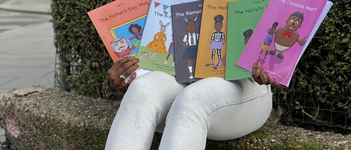 Silvano smiling, holding up the Make Your own Kala books