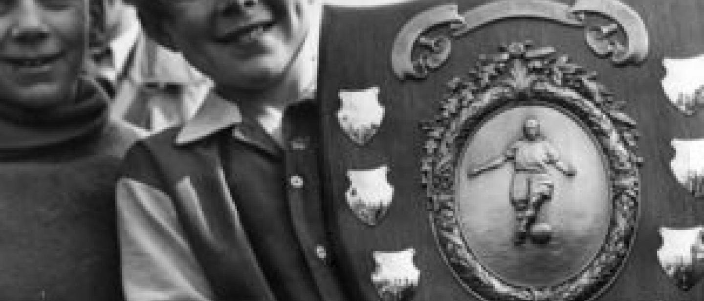 young boy holding a big plague for winners