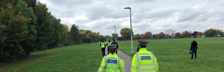 Police and enforcement officers patrolling through park
