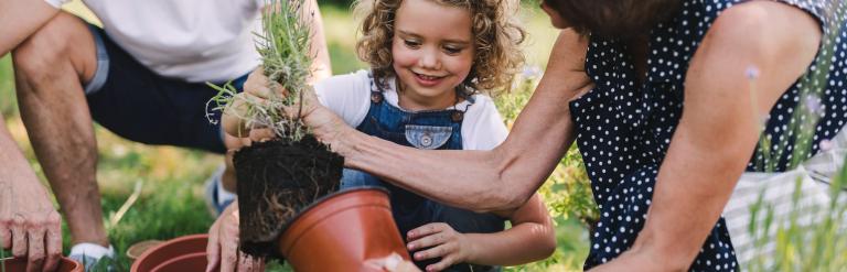 man and woman gardening with young child