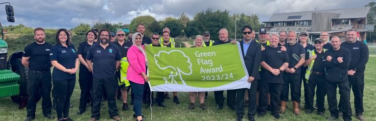 Councillors holding green flag with council staff 