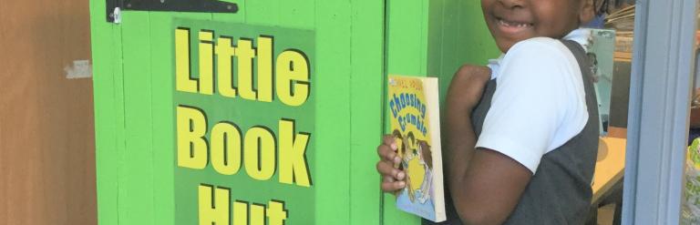 girl with book next to pop up reading hut