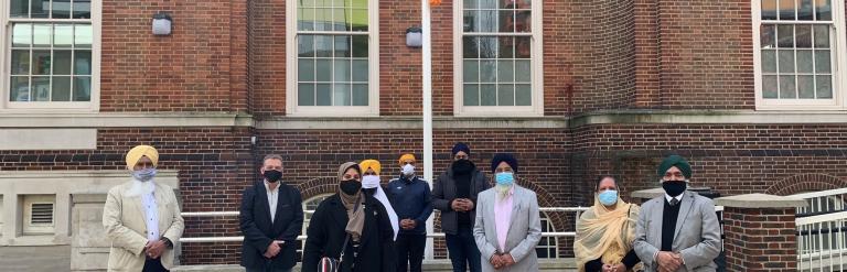 group outside town hall with the khalsa flag