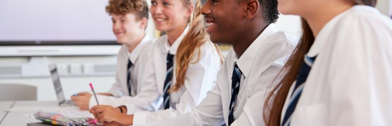 Secondary school children in class smiling