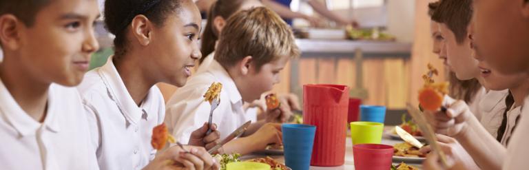 children eating a school meal in canteen