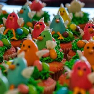 Close up of a group of Easter-themed cupcake top frostings shaped as colourful chicks.