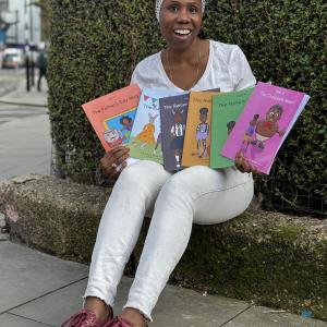 Silvano smiling, holding up the Make Your own Kala books